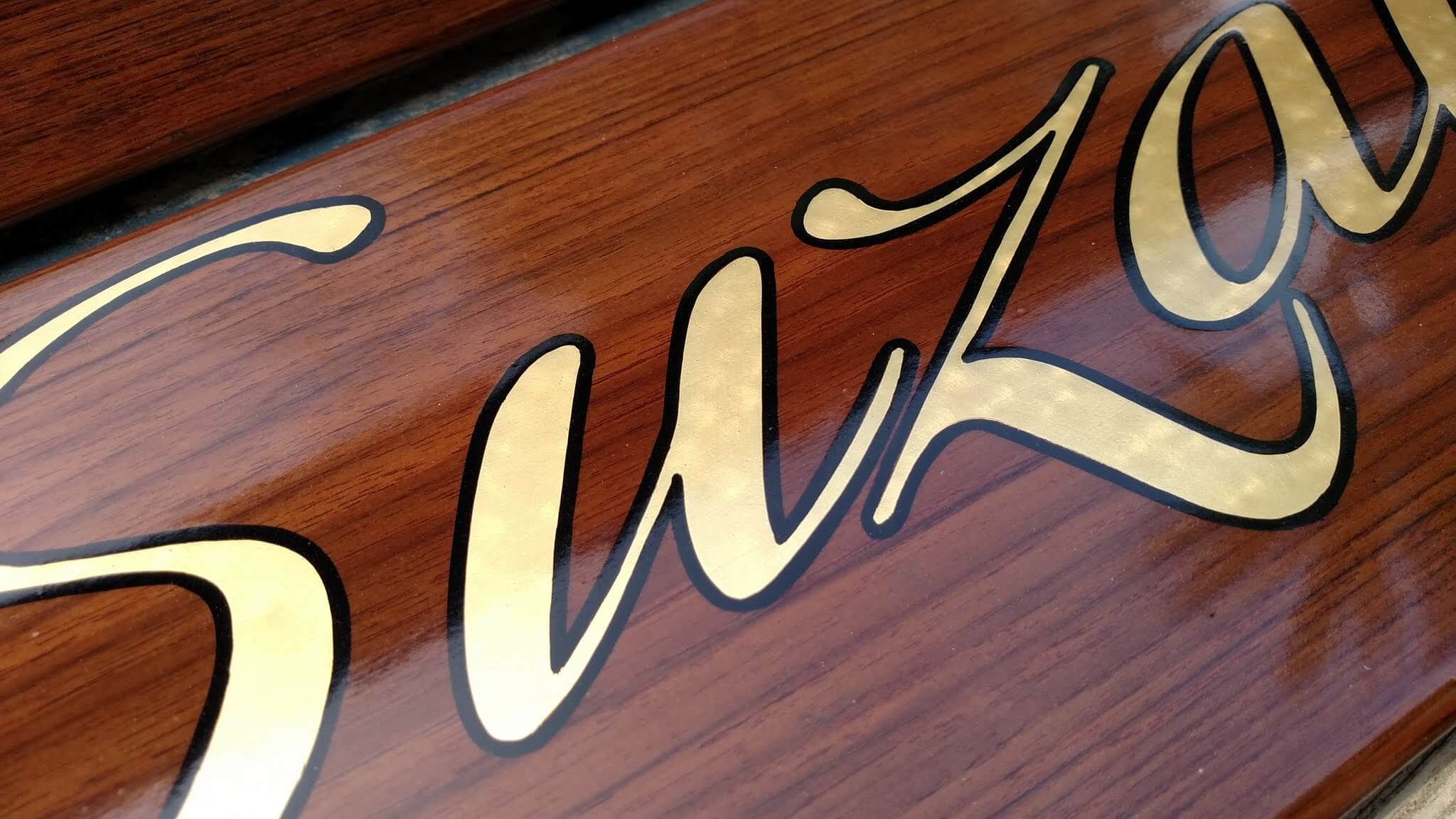 A flat gilded letter with outline