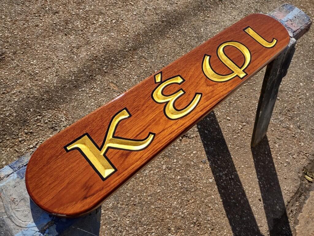 A teak board with carved letters and gold leaf. Boat quarterboards.