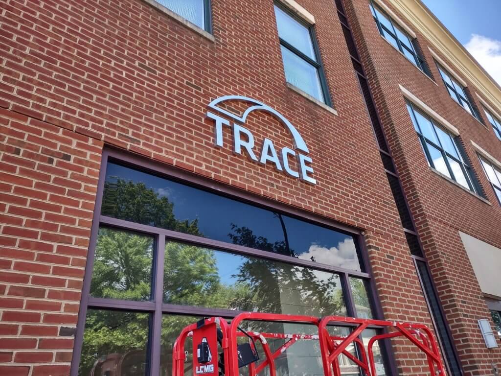 Brushed stainless steel letters, mounted onto a brick wall at Trace offices in Annapolis, MD.