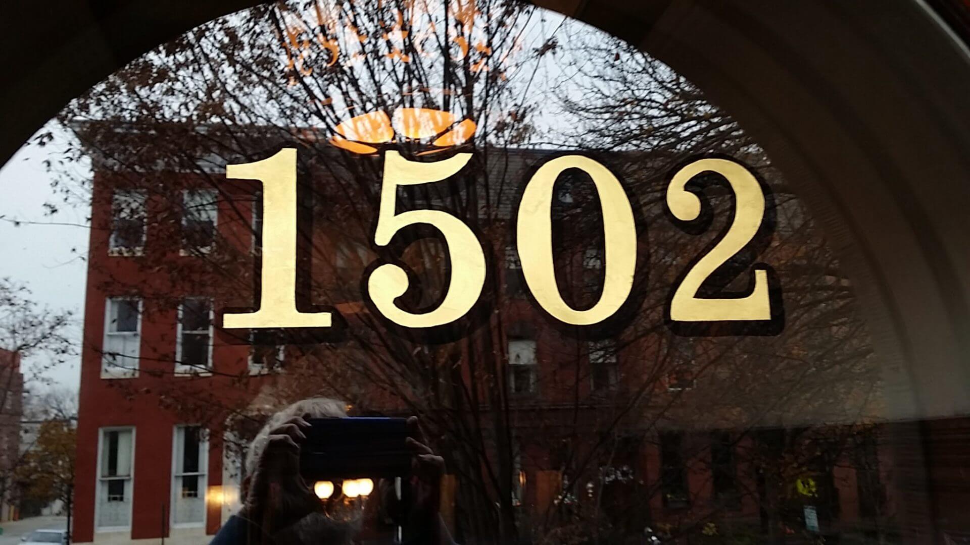 Historic house numbers in gold leaf on a glass transom in Washington, DC