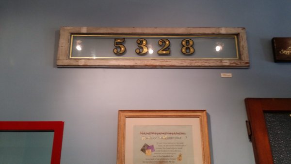 Framed sample of hand gilded house numbers on glass