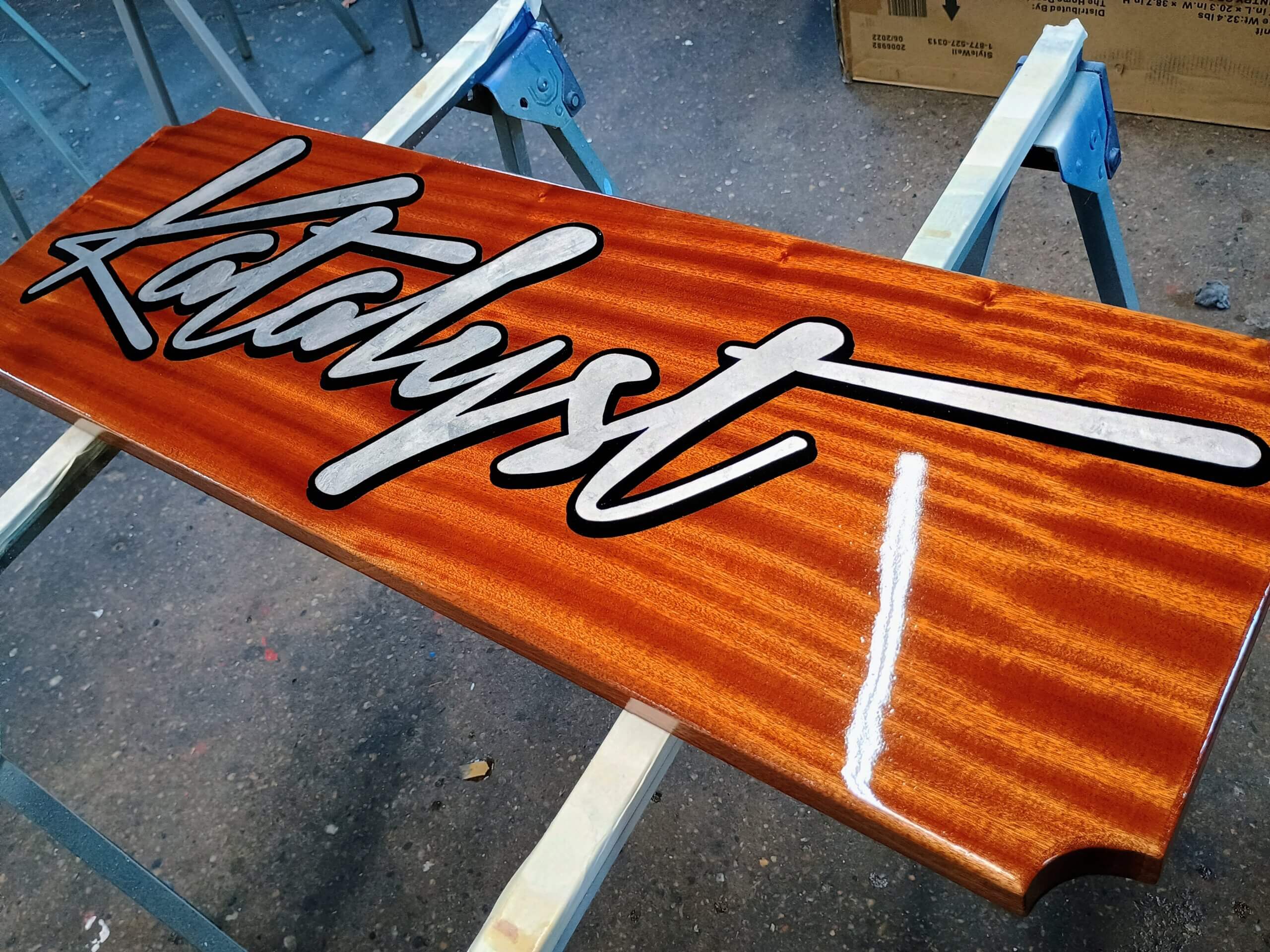 Katalyst palladium leaf quarterboard on mahogany with black outline and shadow