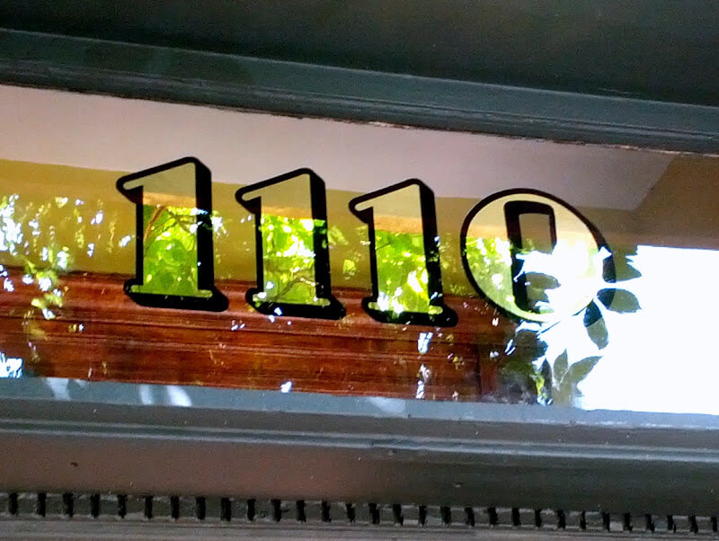 Gold leaf transom numbers on glass above entrance door