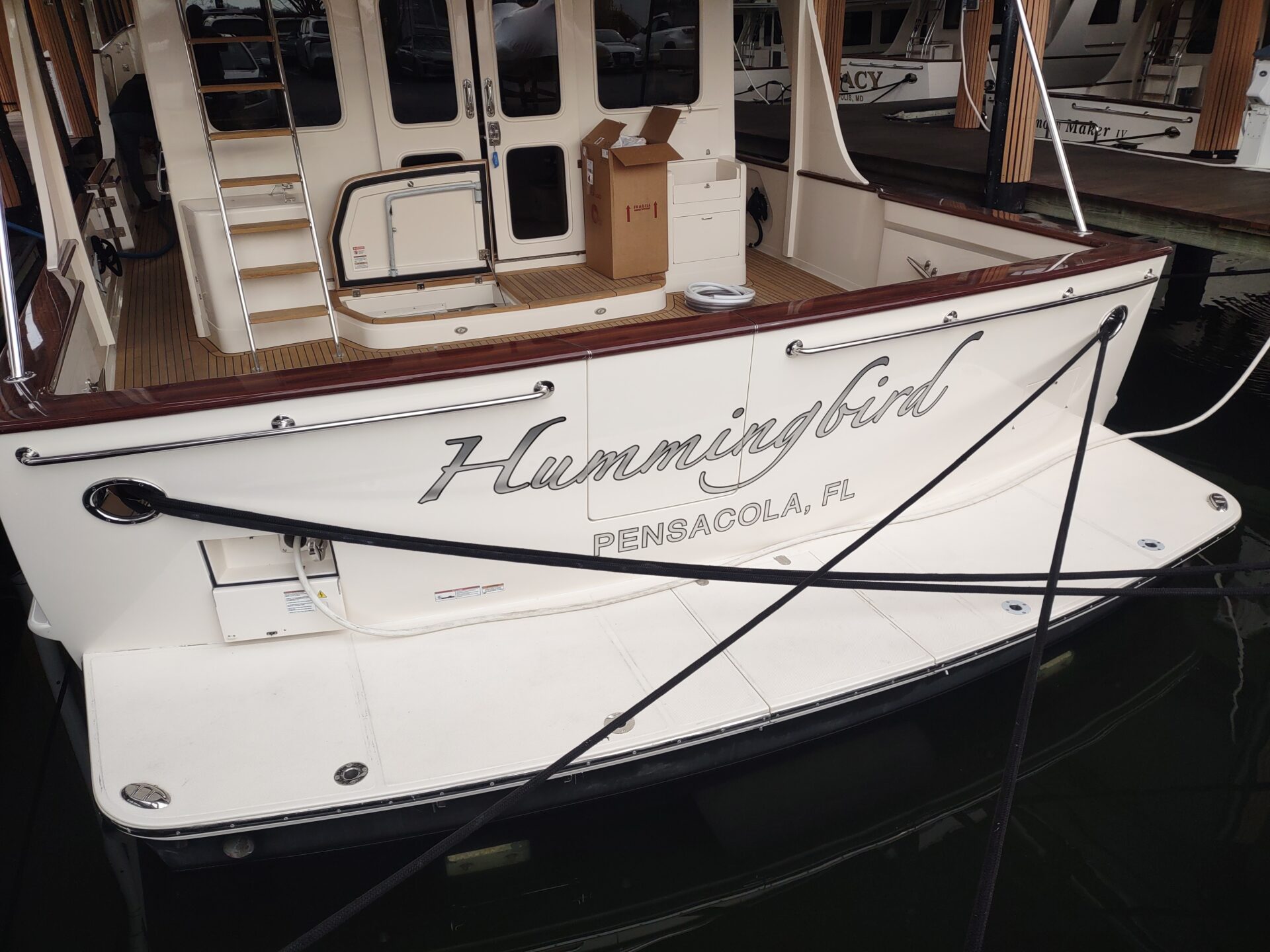 burnished silver leaf script boat name Hummingbird on a Fleming yacht, hailing port Pensacola, FL
