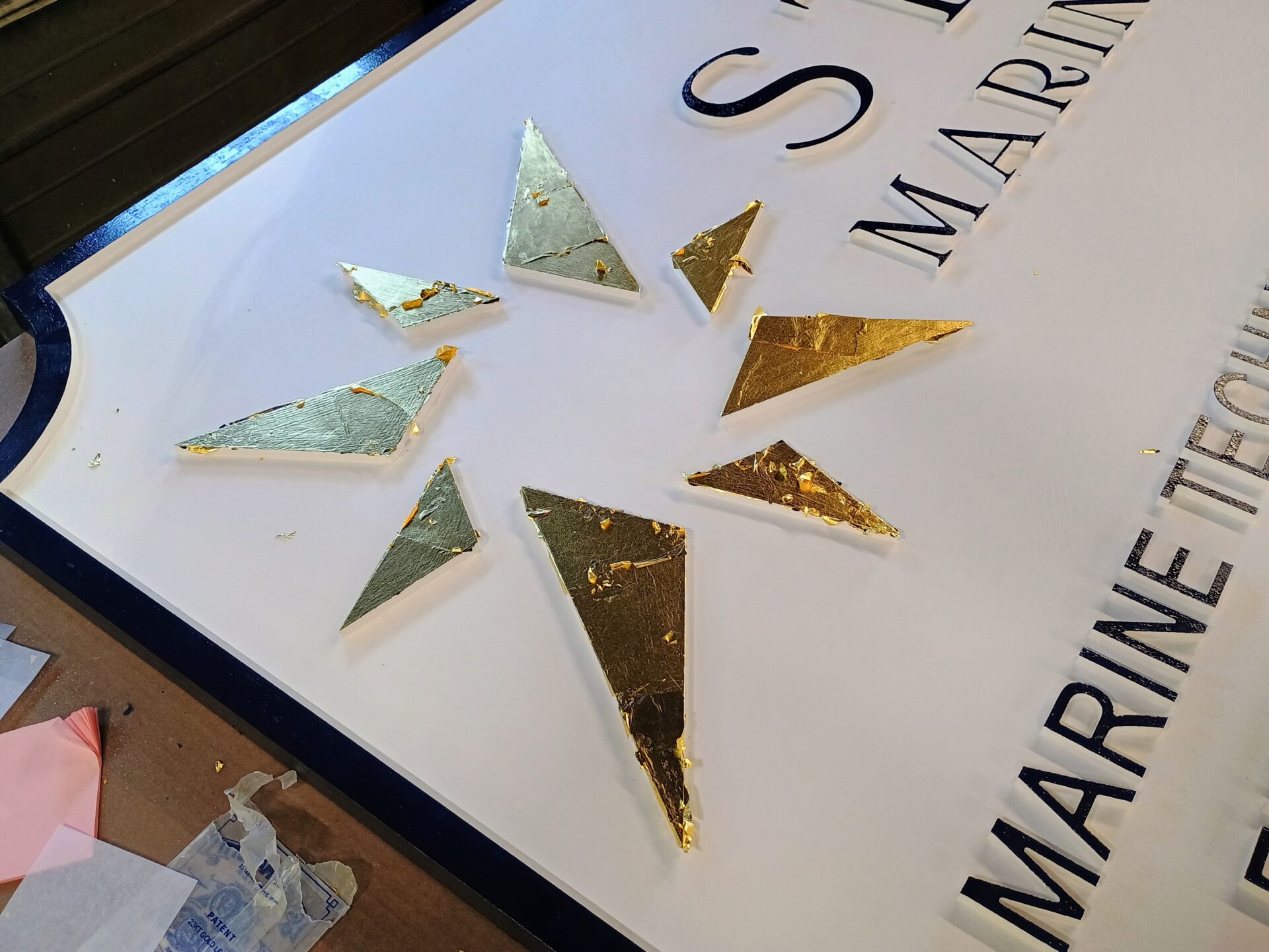 Gold leaf star logo on Stella Marine Services marine business sign in routed HDU