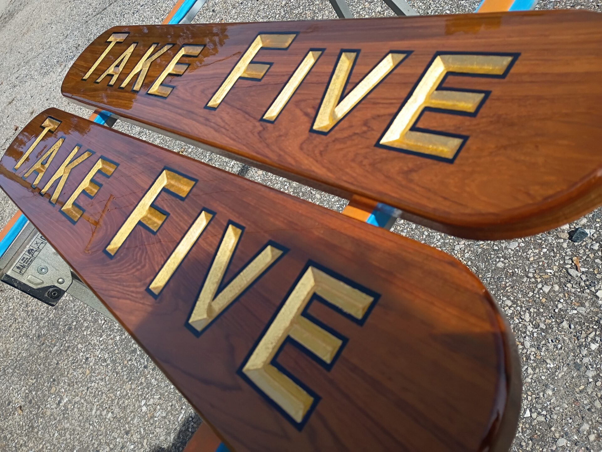 Close-up of carved gold leaf lettering on teak nameboards